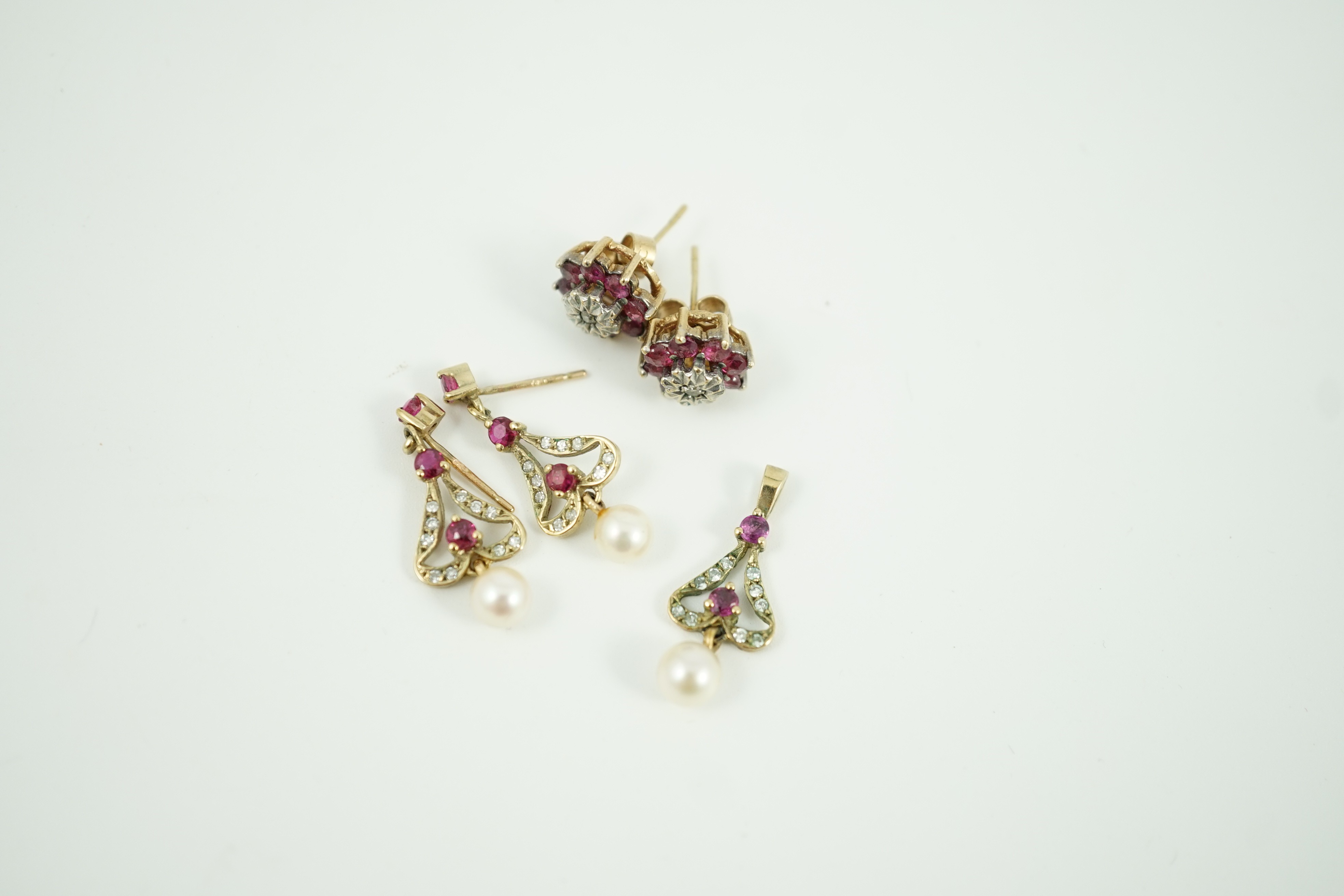 A modern 9ct gold, ruby, diamond and cultured pearl set drop pendant, 22mm and a pair of matching earrings, together with a pair of ruby and diamond cluster set ear studs, gross weight 5.7 grams.